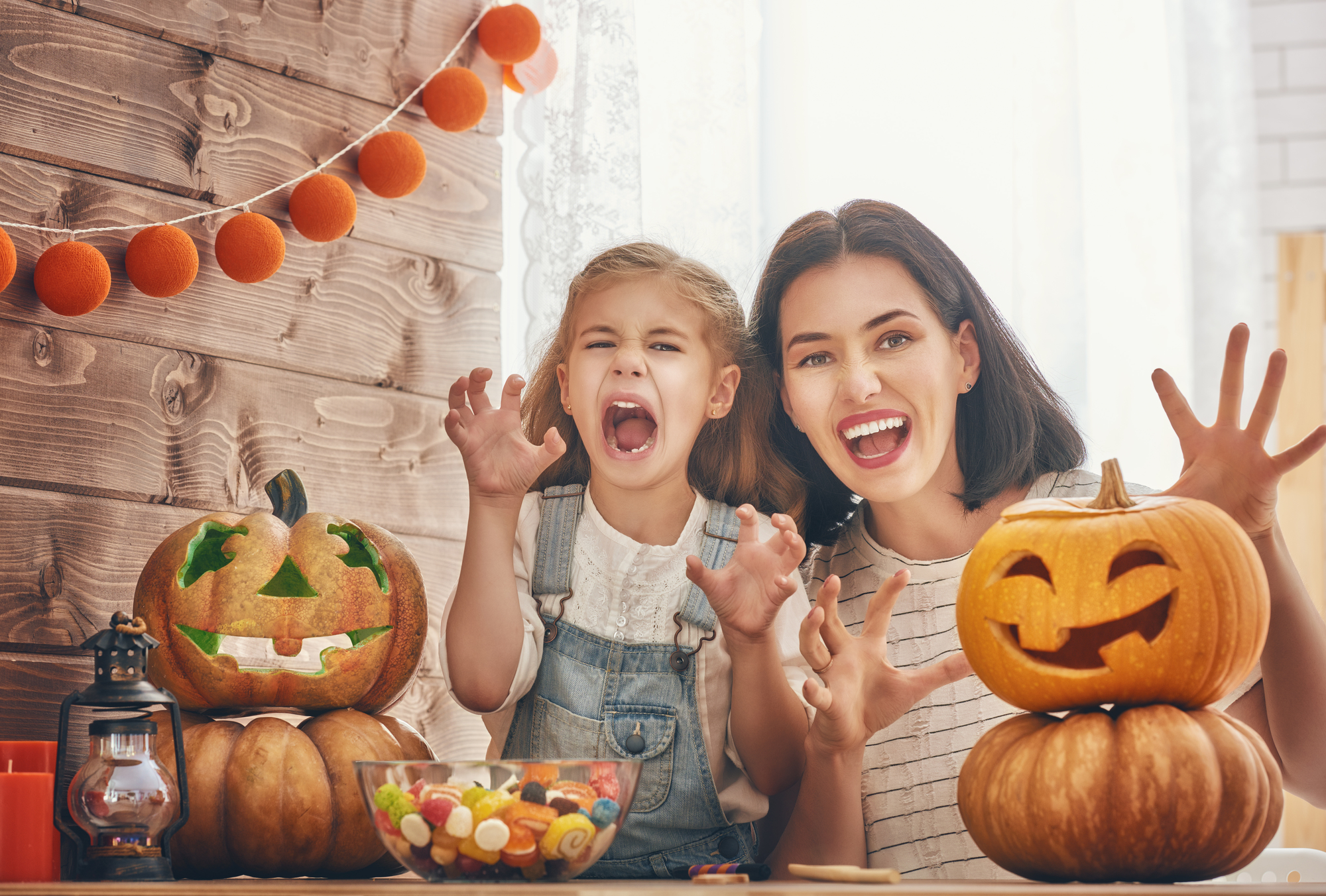 Happy halloween! A mother and her daughter carving pumpkin. Happy family preparing for Halloween.